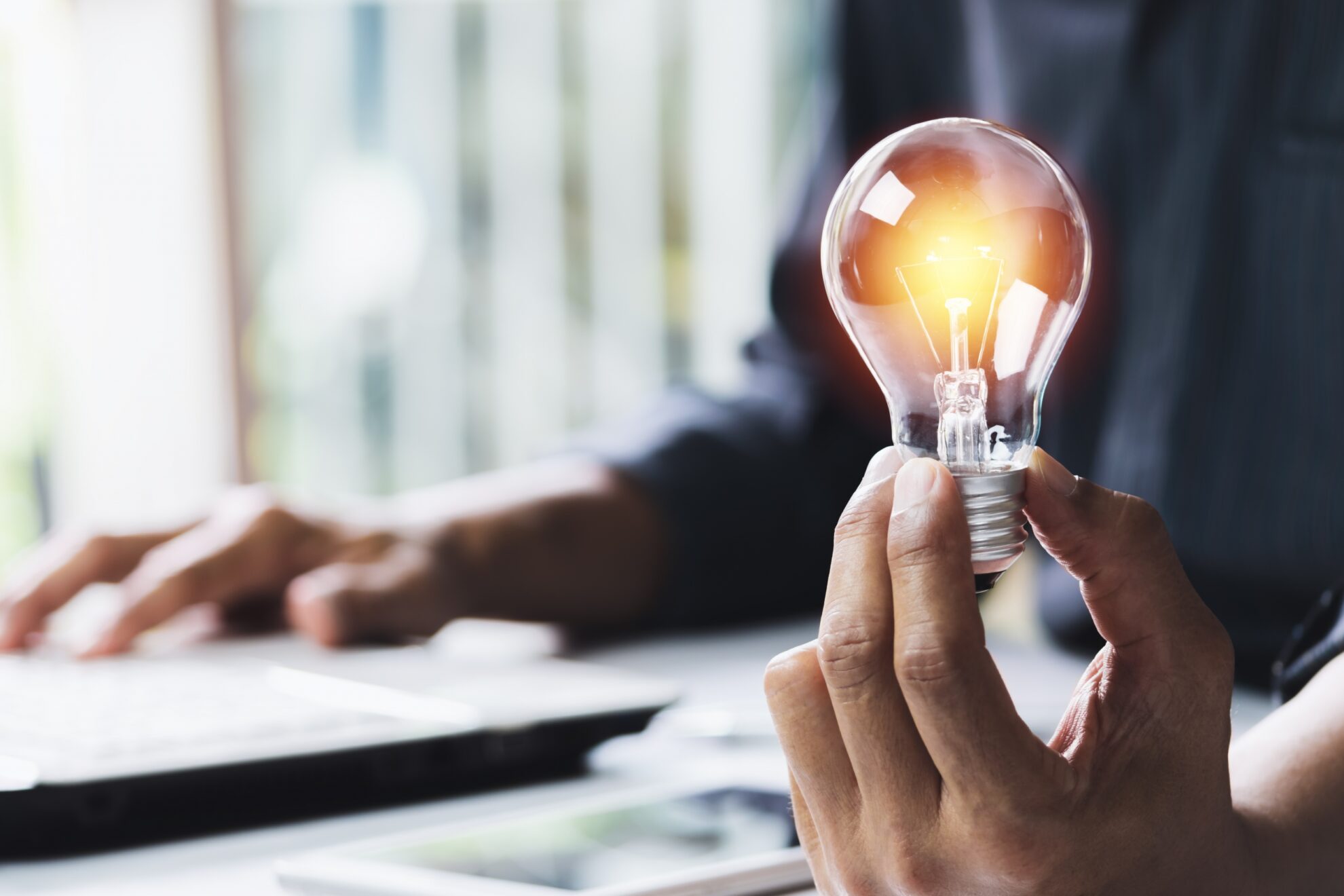 Office worker holding a lit up lightbulb