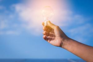 Person holding a lit up lightbulb