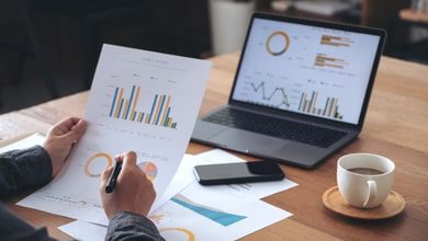 Person working at desk on laptop looking at graphs