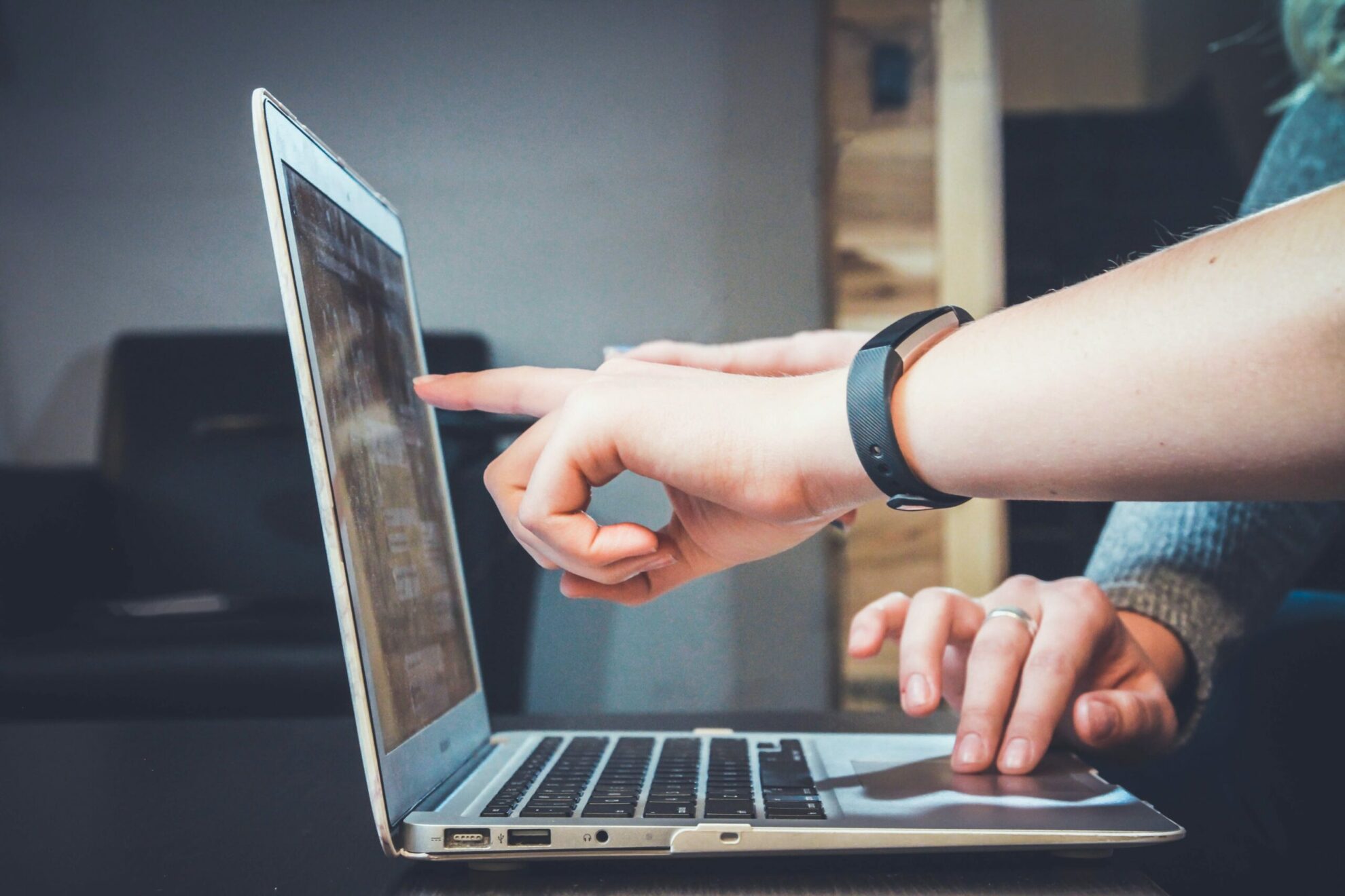 Hands pointing at something on a laptop computer