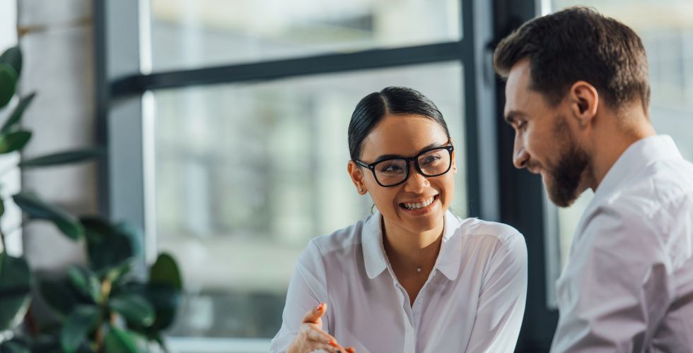 A chief client officer and professional reviewing relationship data as part of a cross-selling discussion to deepen the relationship and offer greater value, highlighting why a Client Centric approach requires unified data to drive collaboration.