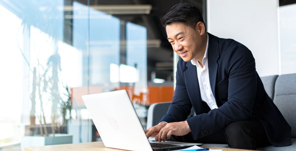 Professional reviewing work on a laptop, representing AI tools used in client relationship management.